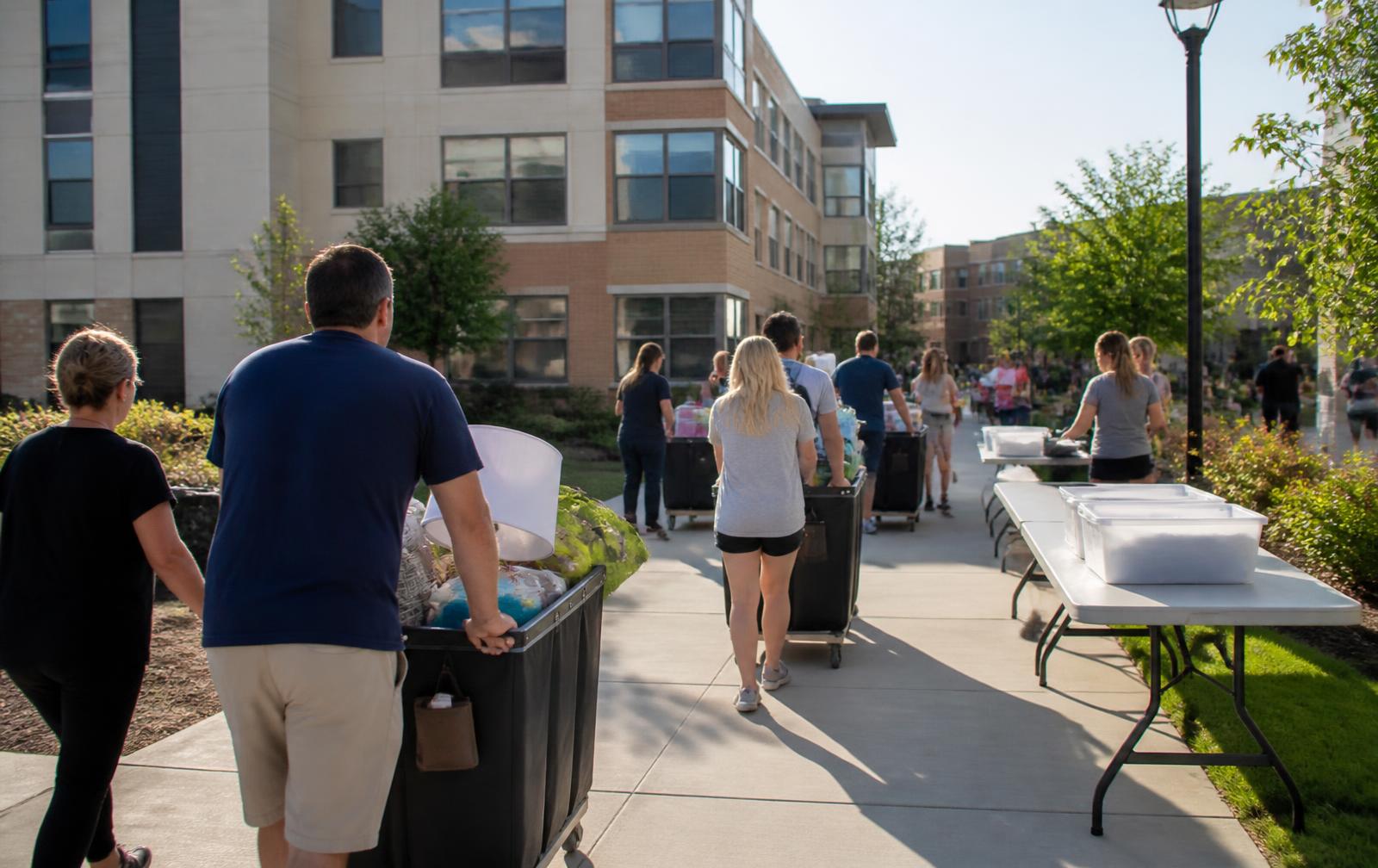 Move-in morning at a student housing community, families unloading cars